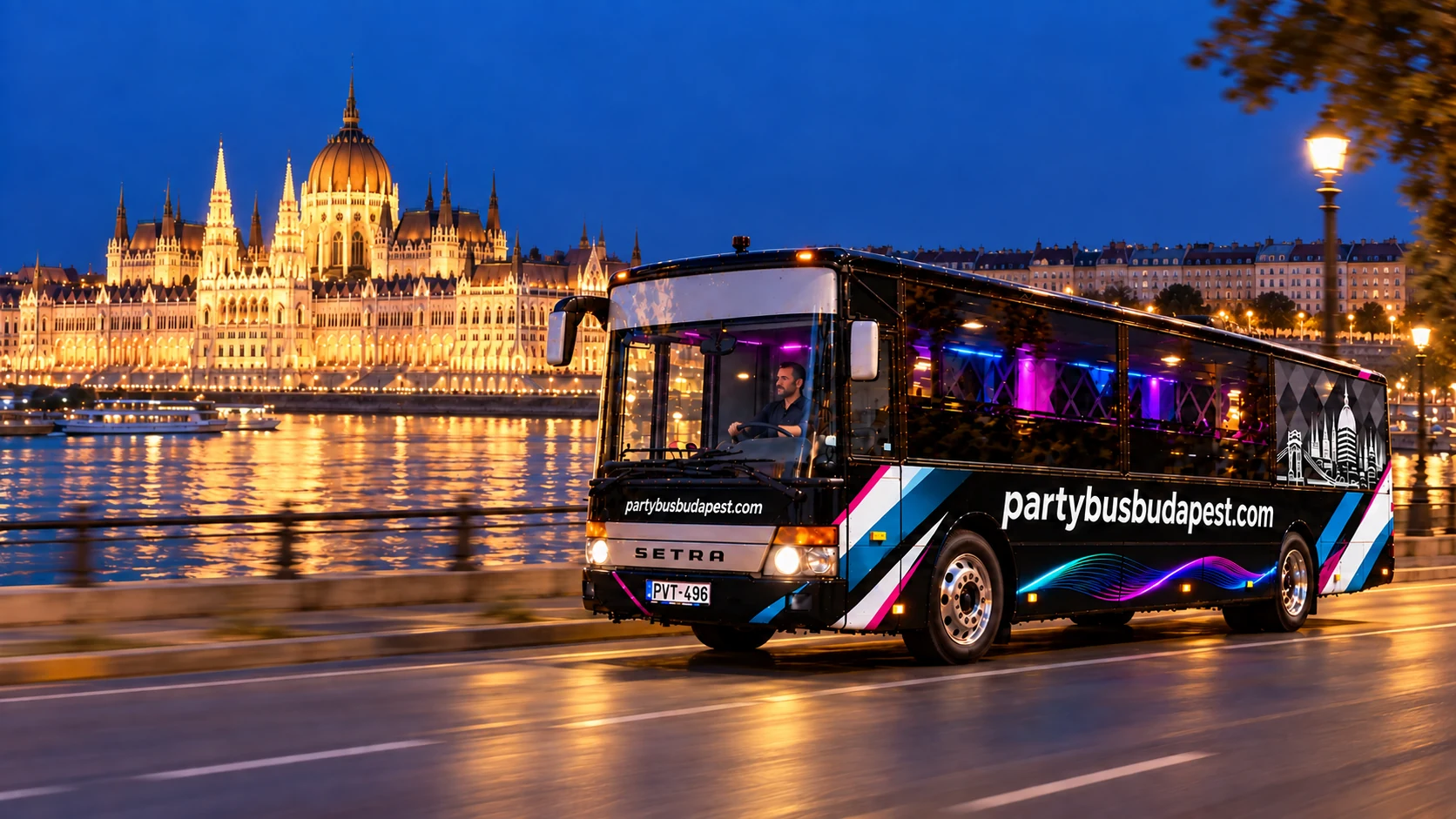 Black party bus on a Budapest riverside road with Parliament across the Danube
